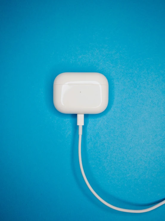 an apple charger is plugged into a blue background