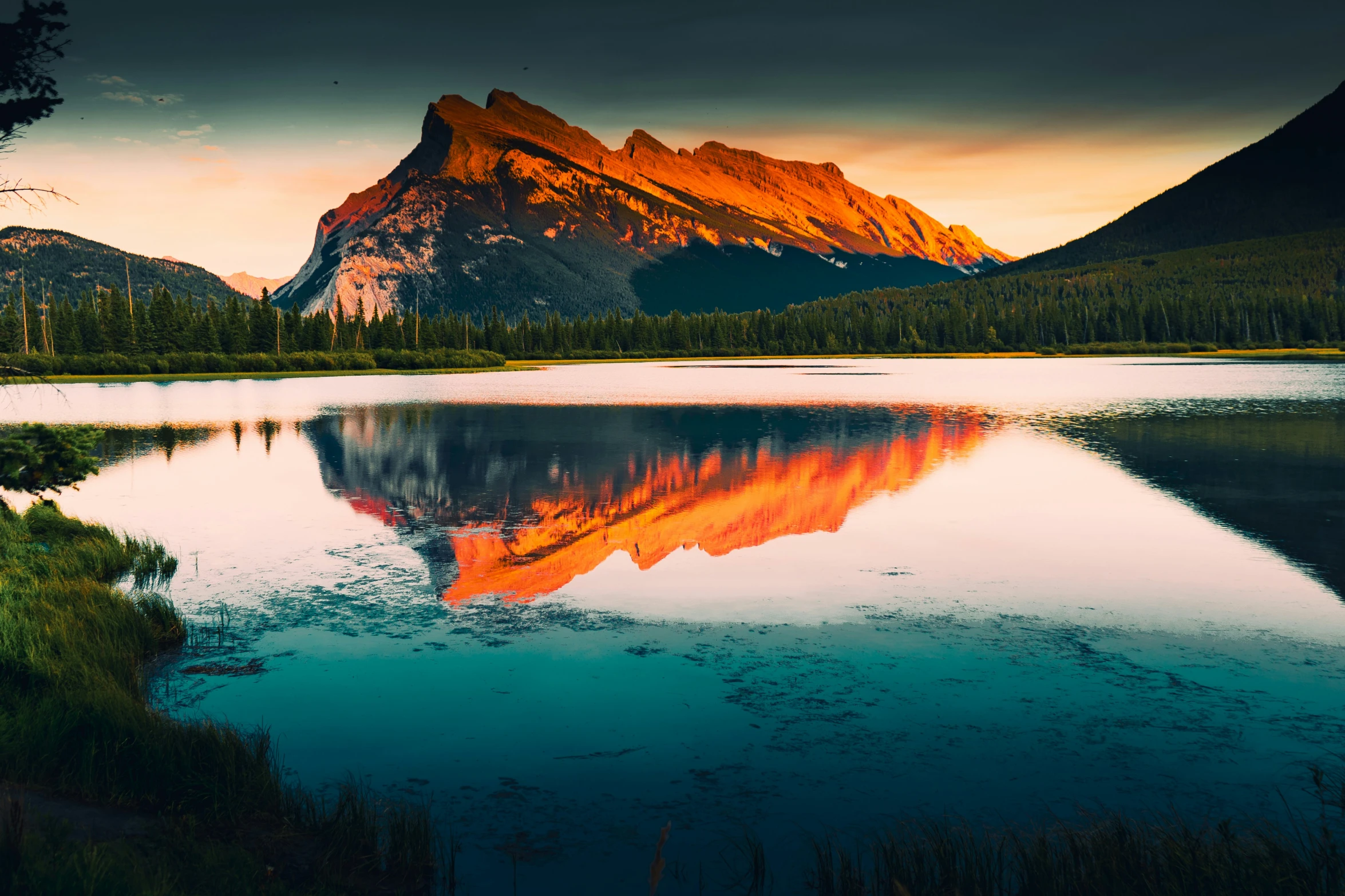 the mountain is rising up behind a lake