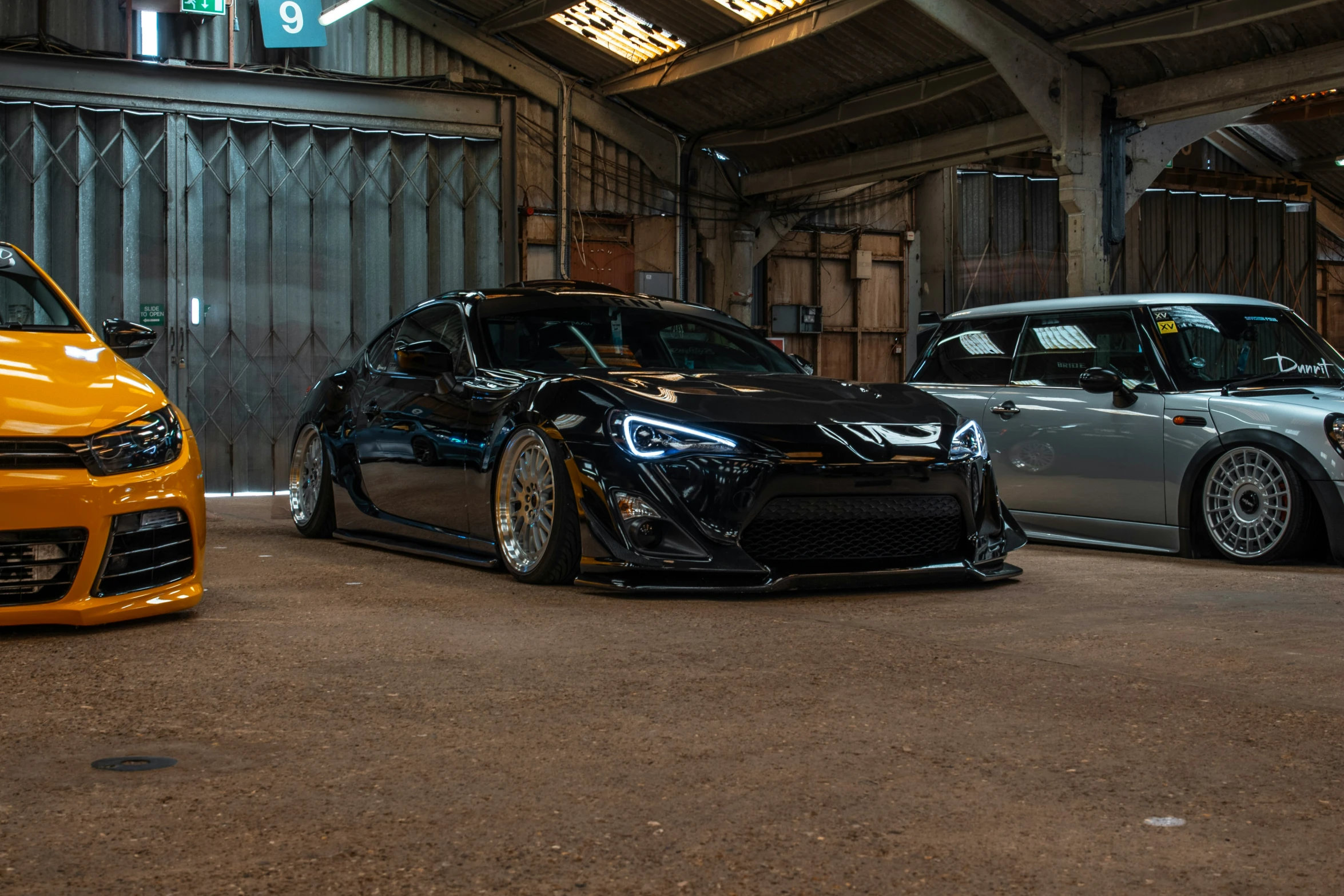 two cars parked in a garage next to each other