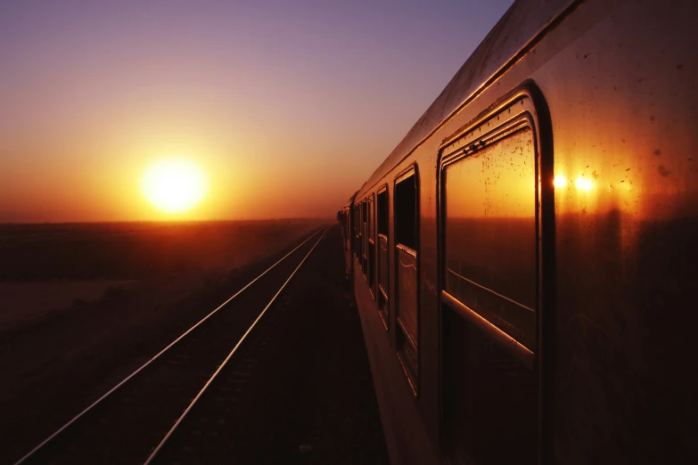 a train at the side with the sun going down