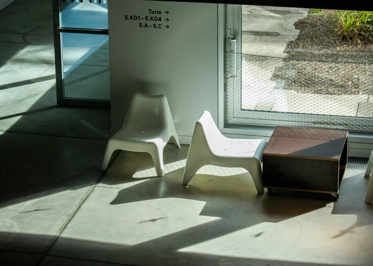 the shadow of a chair is cast on the sidewalk