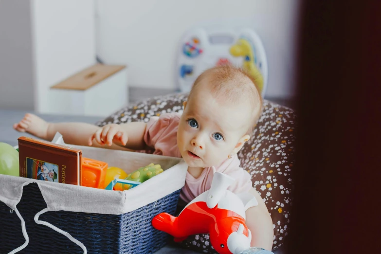 a baby is looking at the camera while she sits on the floor