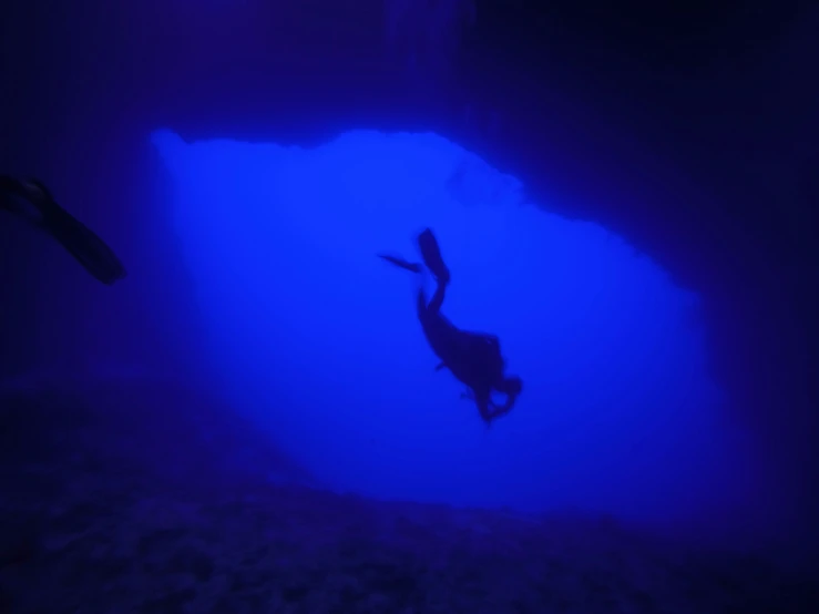 a man swimming underwater next to a diving equipment