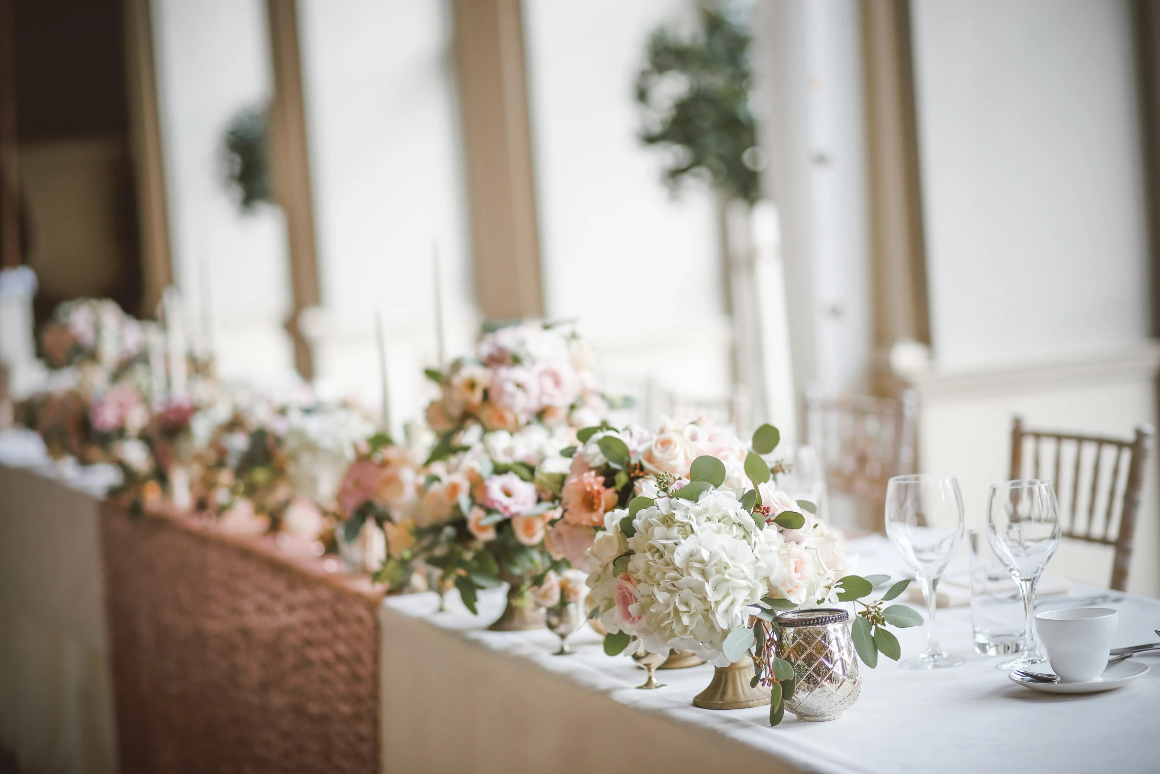 some pretty flowers are on a table by some chairs