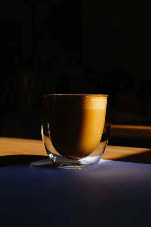 a cup of liquid casts a shadow on the table