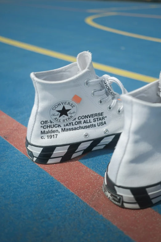 white converse sneakers with black stripes on a basketball court