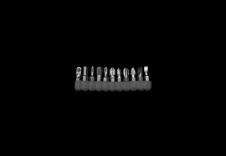 a collection of silver tooth brushes in black background