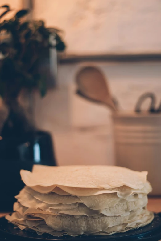 a stack of tortilla dough sitting on top of a black plate