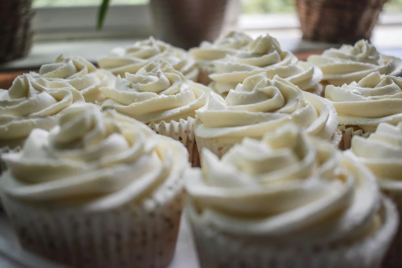 cupcakes with white frosting on a wooden table