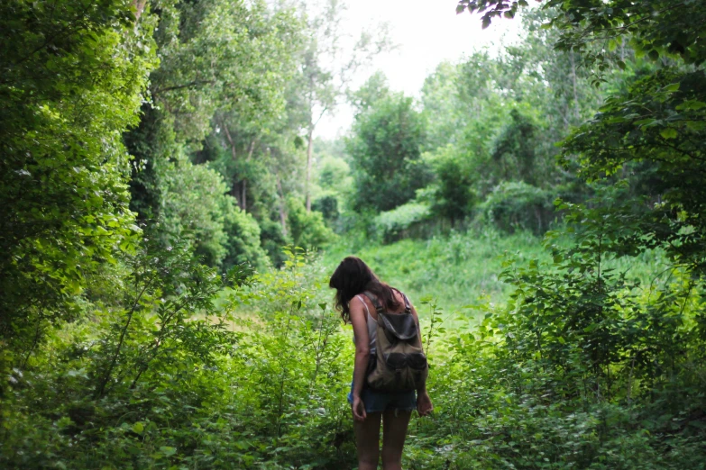 a woman walking in the middle of the forest