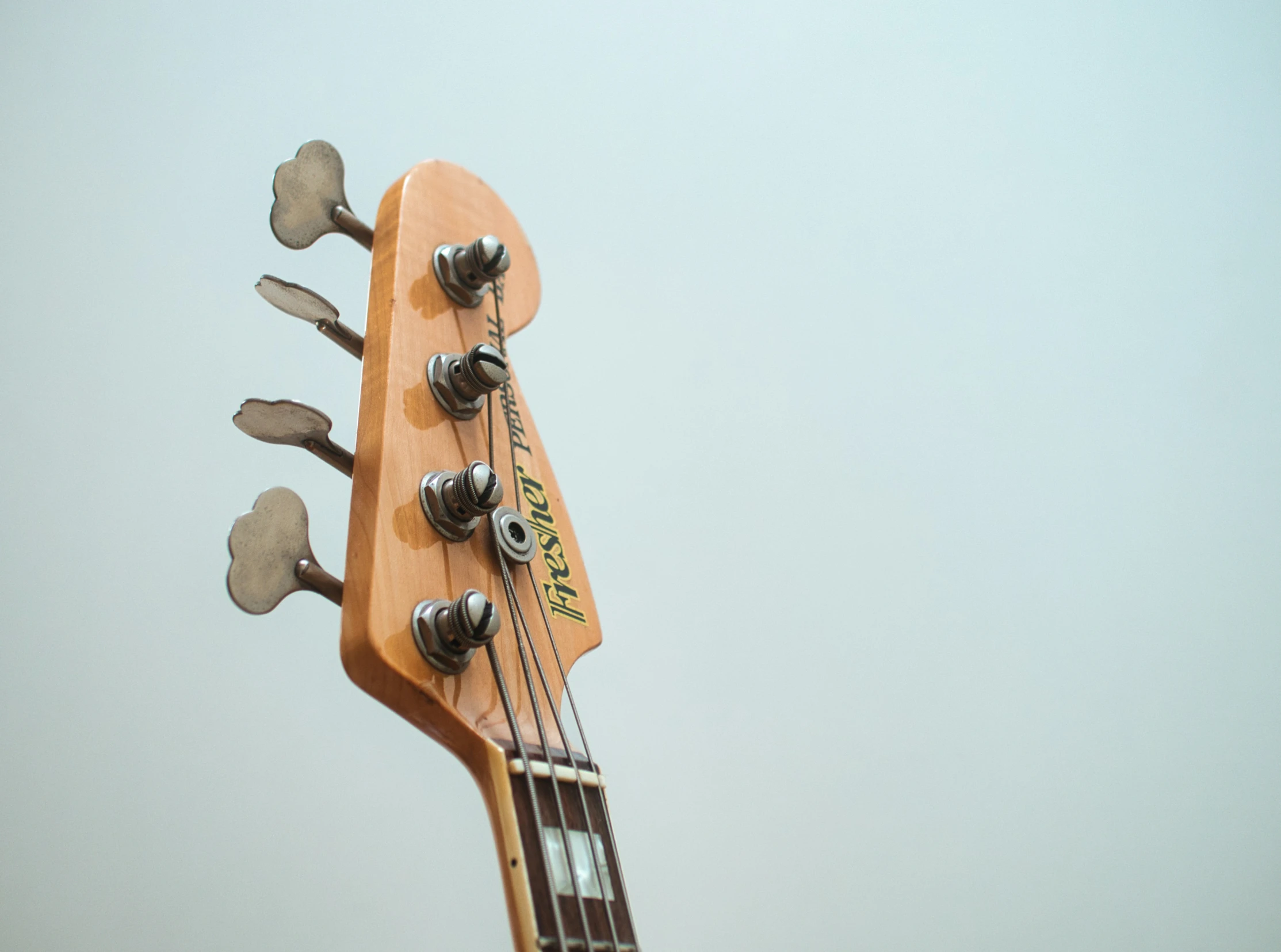 a close up of an electric guitar with four frets and a guitar pickup