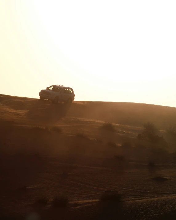 a jeep driving on top of a dirt hill