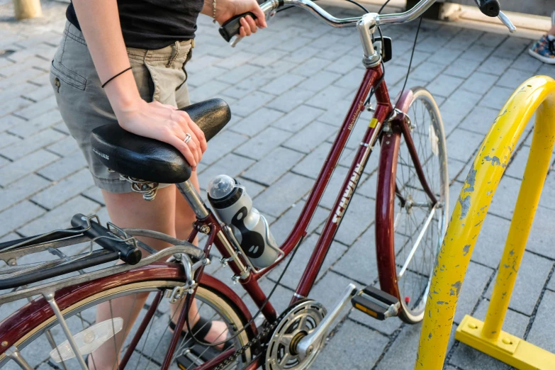 the girl is standing next to a red bike