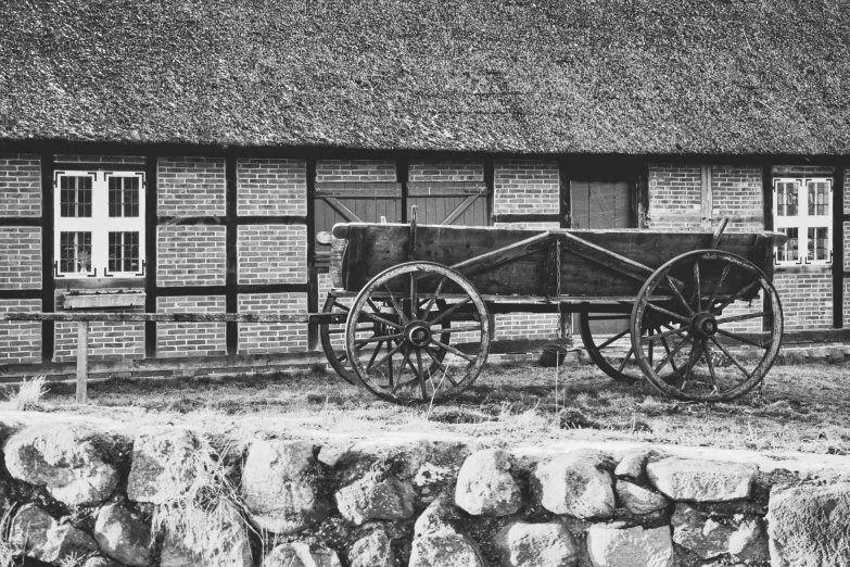 an old wagon stands next to a brick building