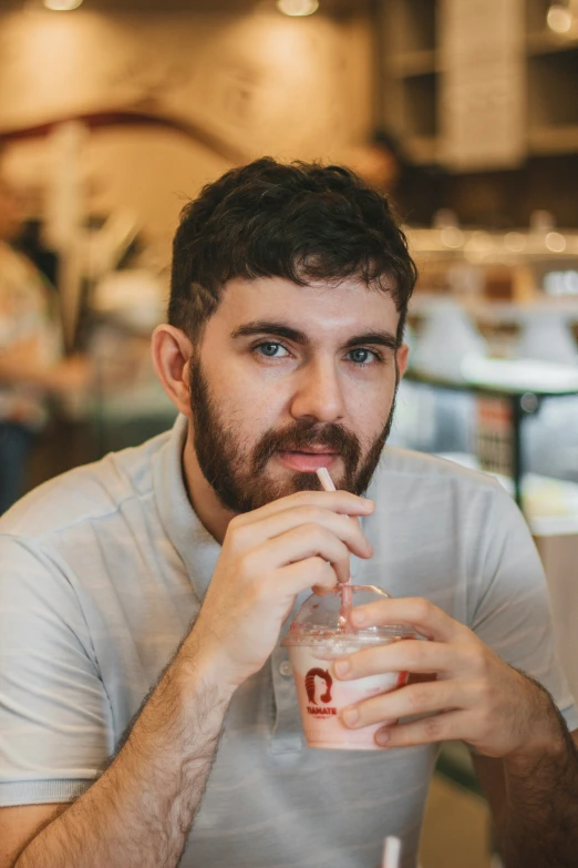 a man with a beard drinking from a glass