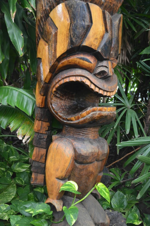 a wooden figure in the middle of some greenery