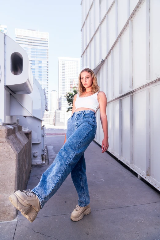 a woman is posing for the camera on a sidewalk