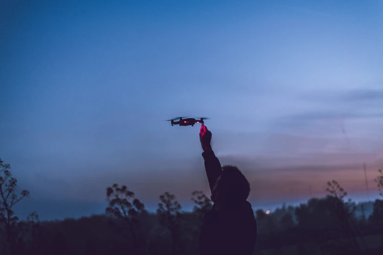 a person reaching up in the air to pick up soing