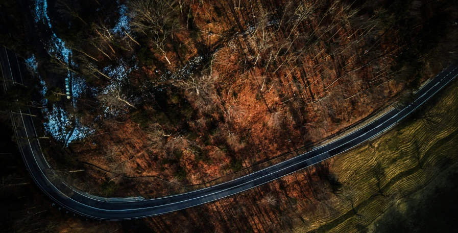 an overhead view of a highway surrounded by trees