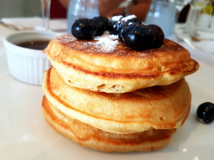 a stack of pancakes with blueberries and syrup
