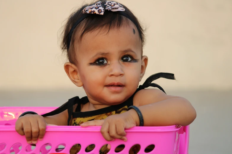 a baby with blue eyes is in a pink box