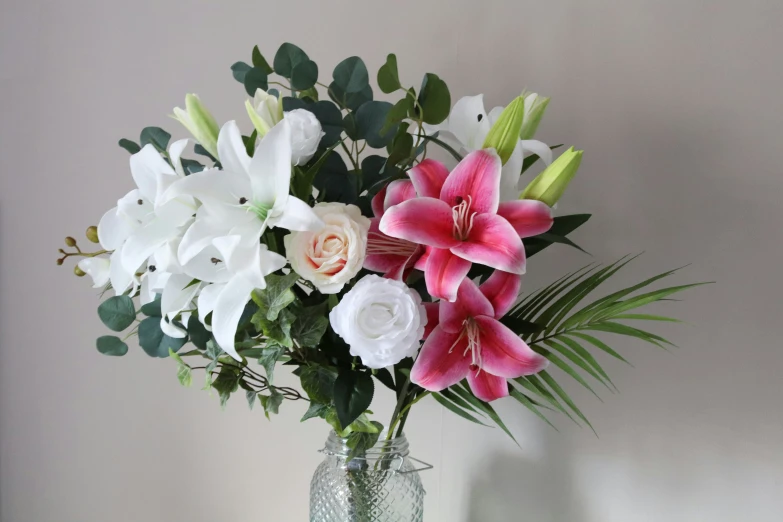 the white and pink flowers in a vase are on display