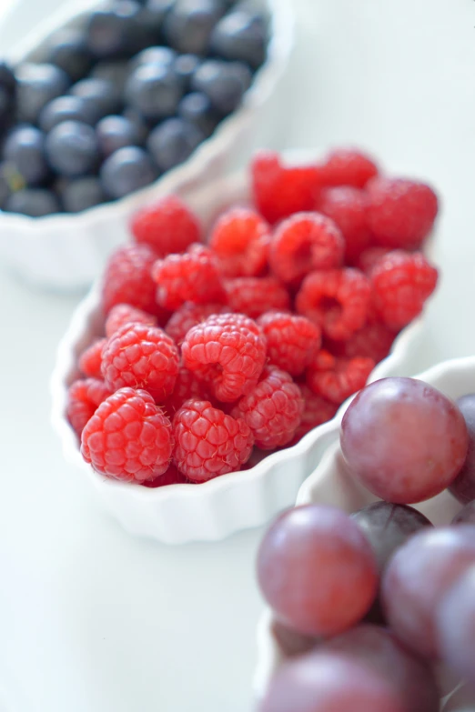 a group of bowls filled with different types of berries