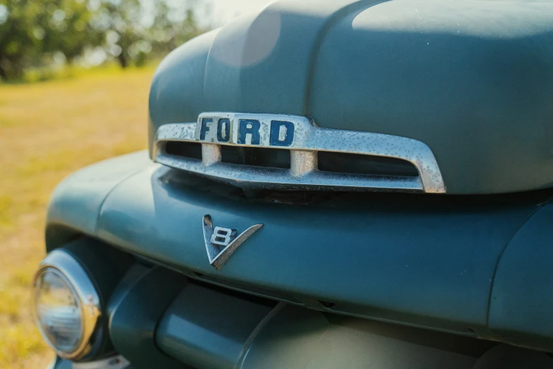 a close up view of the front of a green car with a hood or grill