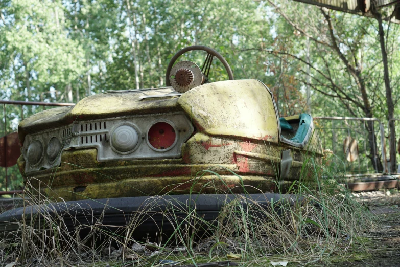 an abandoned car sits abandoned in the woods