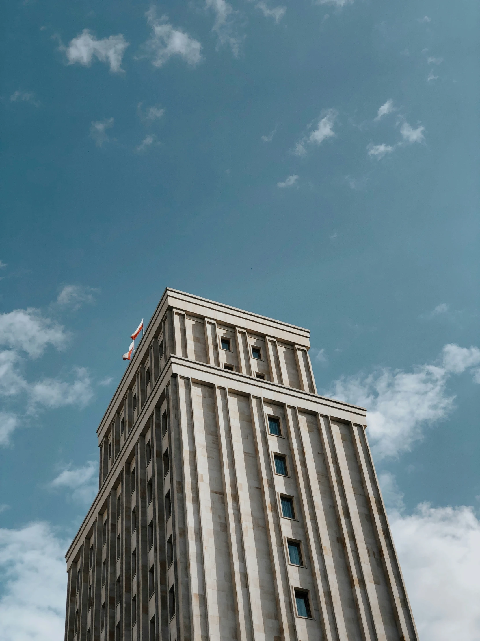 the top part of a skyscr building that has a flag on it