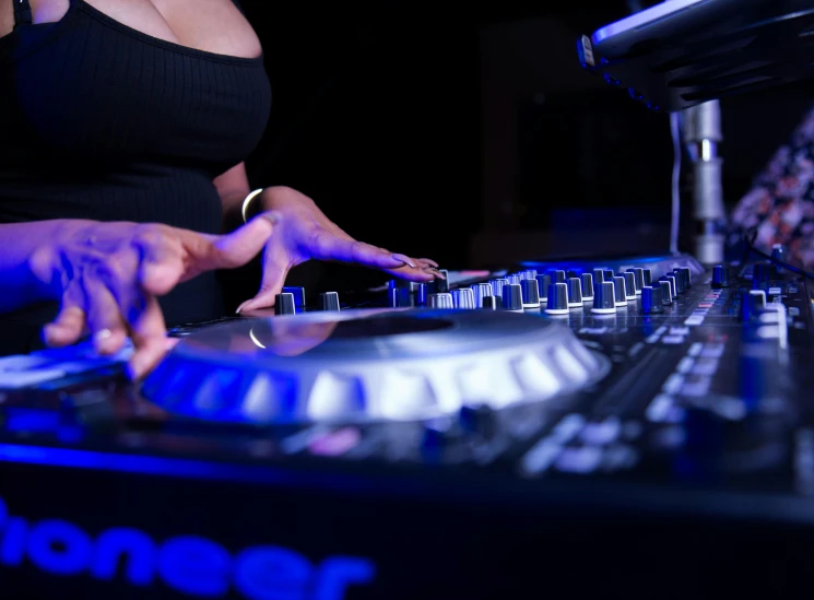 people reaching out their hands to touch a dj's control board