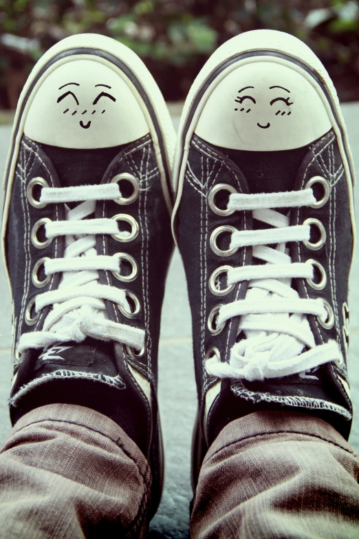 a person's shoes with eyes drawn in them