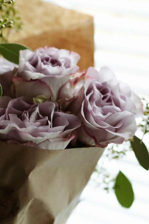 flowers in a brown bag next to other flowers