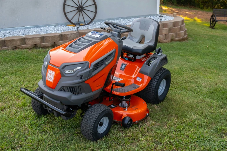 a lawnmower sitting in the grass near a house