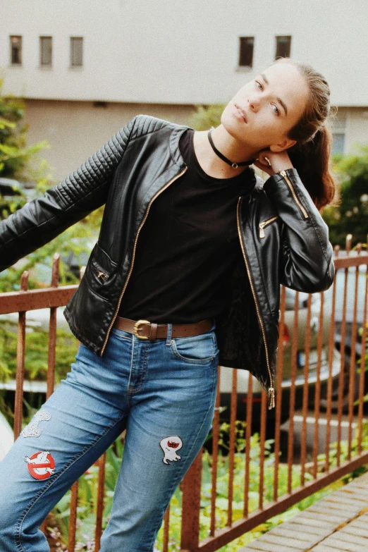 a woman with blue jeans, a black shirt and a leather jacket