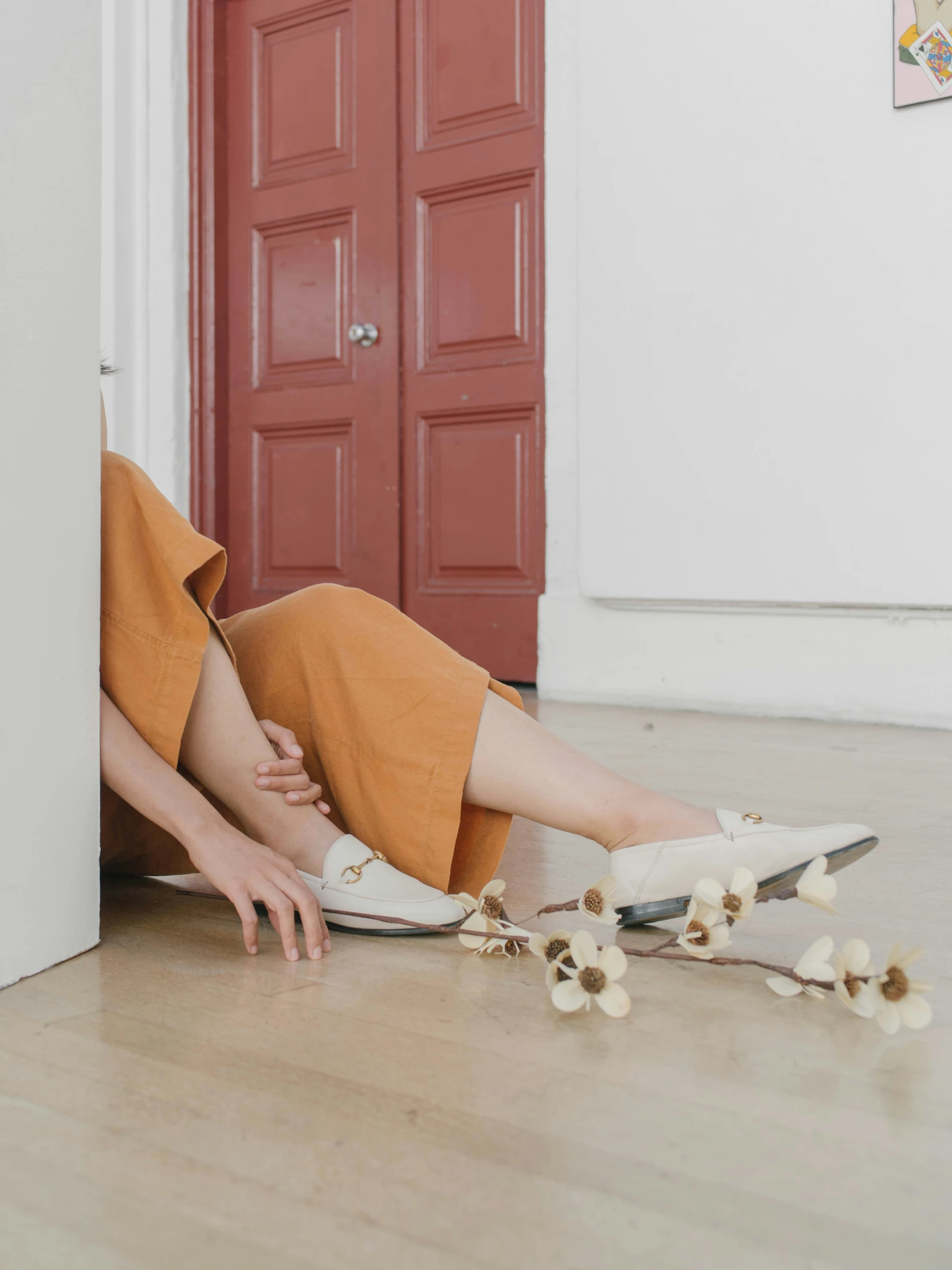 a woman in an orange dress is laying on the floor