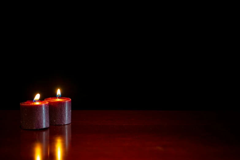 two candles in the shape of a cylinder on a table