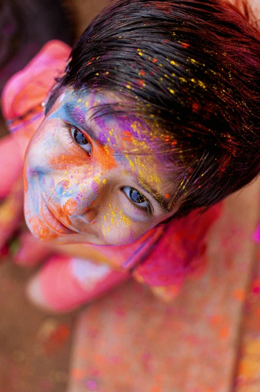 a young child is covered in colored powder