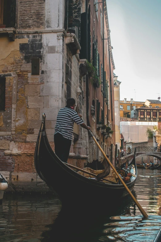 a man with a stick standing in the gondola