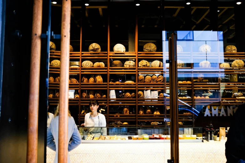 a man standing in front of a counter filled with bread