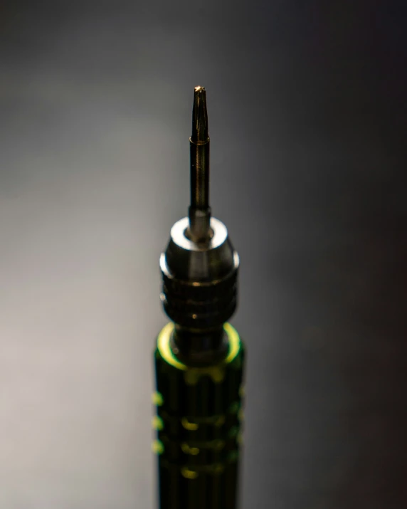 a green glass bottle filled with liquid on top of a table