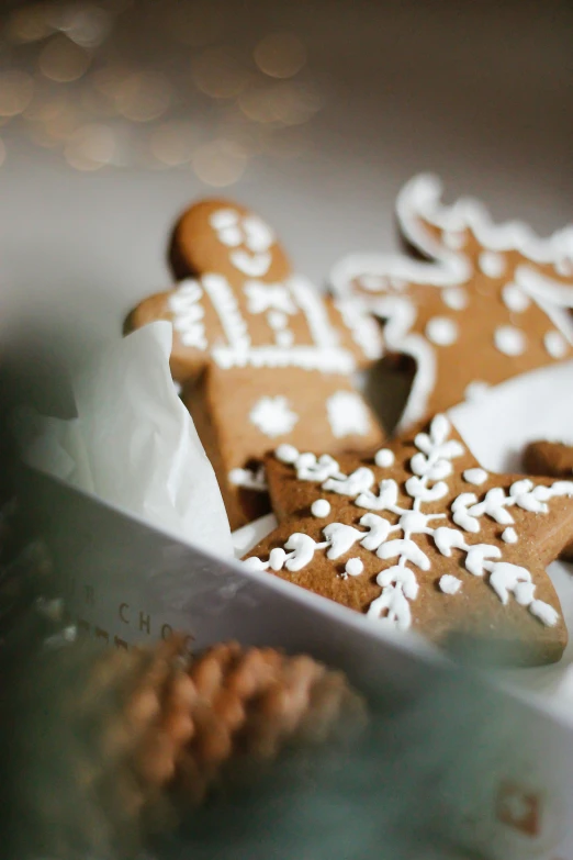 several decorated cookies in a white container with a knife