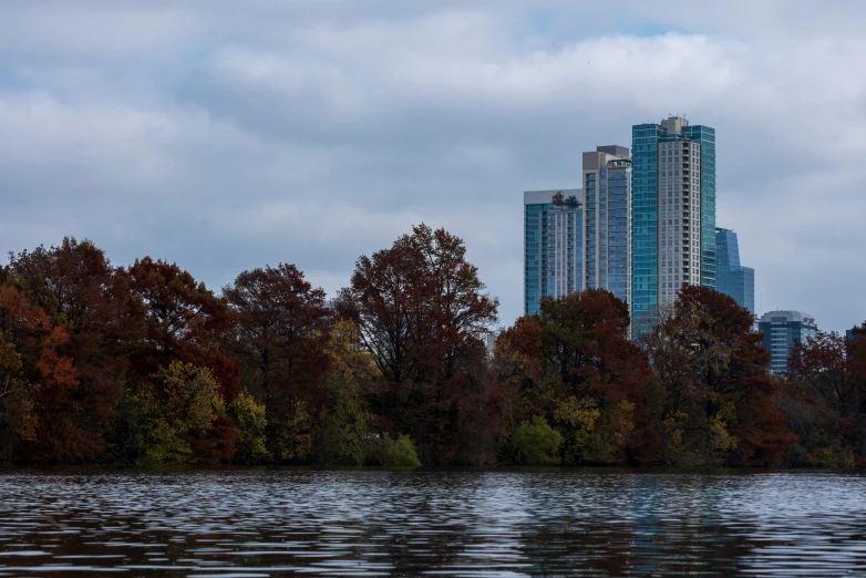 some buildings and trees over looking a lake