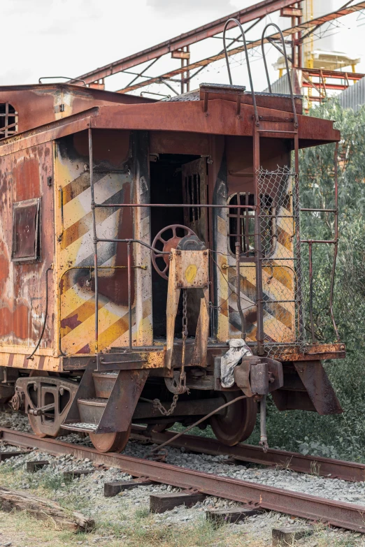 a rusted out train caboose that is on a track