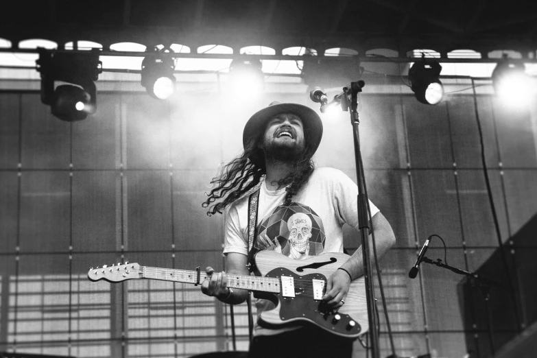 a man is singing and playing guitar while others are in the background