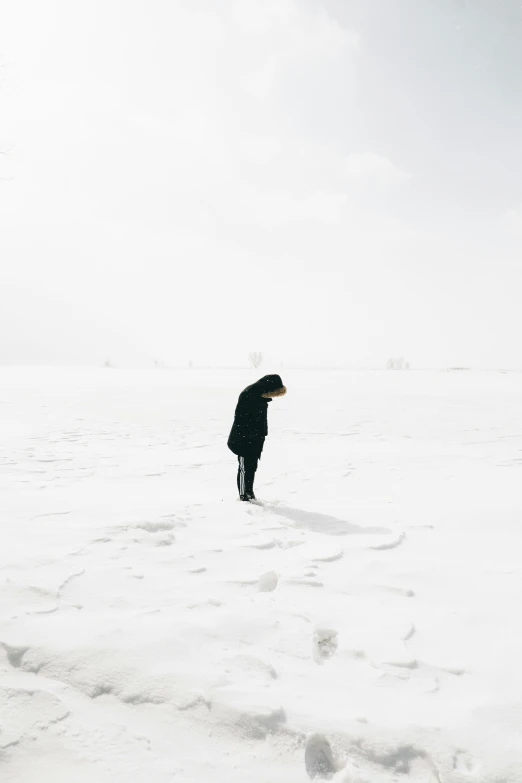 the man is walking in the snow holding onto a kite