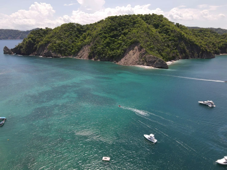 an island surrounded by several small boats in the ocean