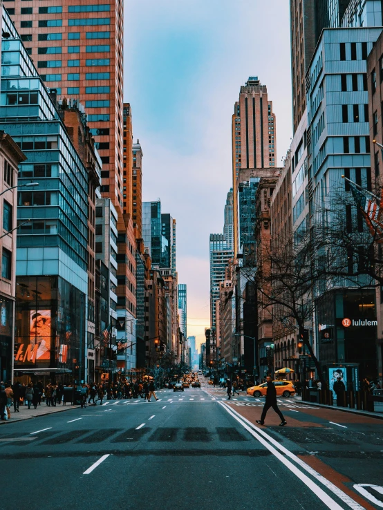 a person walking down a street near tall buildings