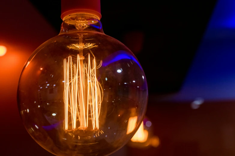 a very big light bulb sitting next to some candles