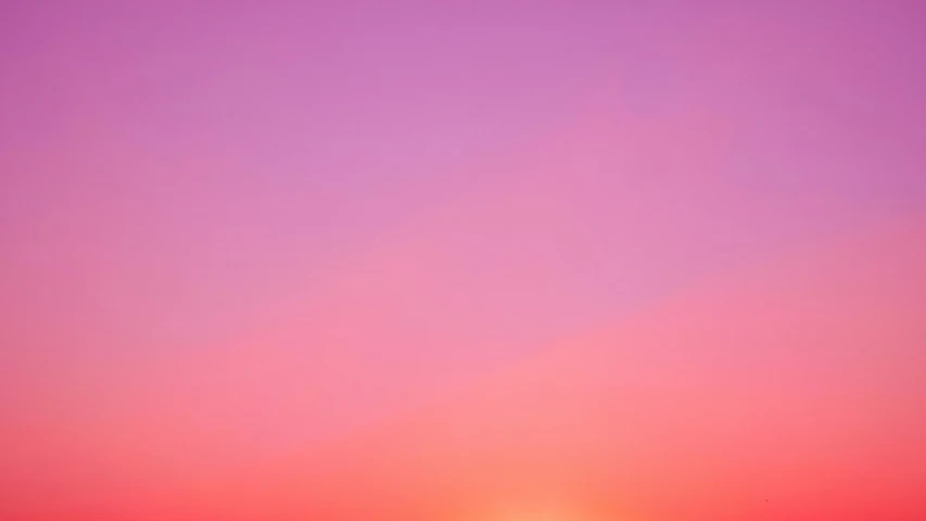 a lone boat is silhouetted in the pink sunset